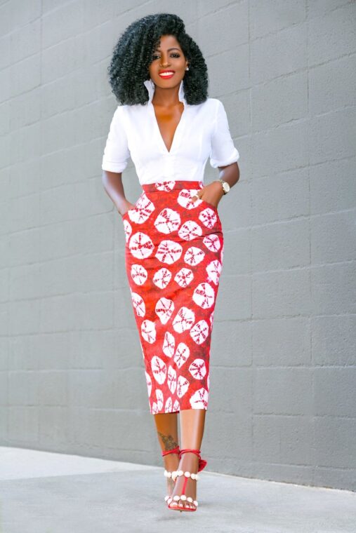 A high-waisted Ankara pencil skirt paired with a white blouse and a statement necklace